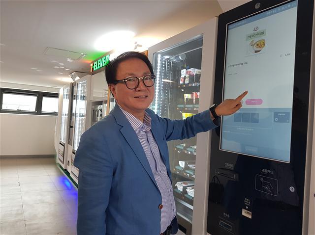 세븐일레븐이 21일 본사가 위치한 서울 중구 시그니처타워에서 자판기형 편의점 ‘세븐일레븐 익스프레스’의 시범운영을 시작했다. 지난 20일 시그니처타워 17층에 위치한 세븐일레븐 익스프레스에서 키오스크를 직접 조작해보는 정승인 세븐일레븐 대표.