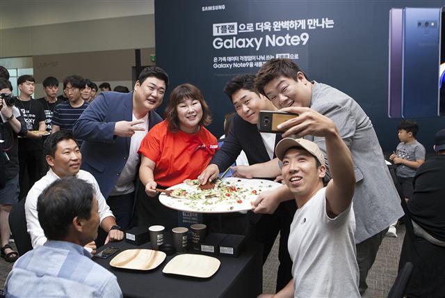 지난 20일 노보텔 앰배서더 서울 동대문에서 열린 KT의 ‘갤럭시노트9’ 사전개통 기념 행사에서 참석자들이 갤노트9을 체험하고 있다.[제공=KT]  (오른쪽)21일 서울 을지로 SK텔레콤 본사 T타워에서 열린 ‘갤럭시노트9’ 사전개통 행사에서 방송인 김준현, 유민상, 김민경, 문세윤이 참석자들과 기념사진을 찍고 있다. 이날 행사에는 참석자들이 ‘T플랜’의 넉넉한 데이터를 상징하는 지름 60㎝ 대형 피자를 나눠먹는 시간을 가졌다.
[제공=SK텔레콤]