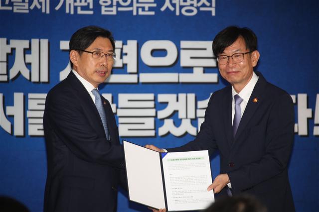 박상기 법무부 장관(왼쪽)과 김상조 공정거래위원장이 21일 서울 세종로 정부서울청사에서 ‘공정거래법 전속고발제 개편 합의문’에 서명한 뒤 악수하고 있다. 양측은 중대담합의 경우 공정위의 고발없이도 검찰이 조사에 나설 수 있도록 합의했다.  [연합뉴스]