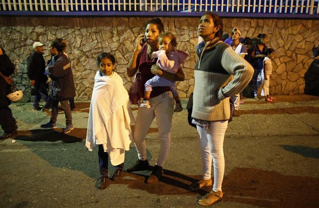 <YONHAP PHOTO-2910> Residents stand outside their apartments in a street near the "Tower of David" skyscraper, which suffered an inclination after a powerful earthquake shook eastern Venezuela, causing buildings to be evacuated in the capital of Caracas, Venezuela, Tuesday, Aug. 21, 2018. The quake was felt as far away as Colombia's capital and in the Venezuelan capital office workers evacuated buildings and people fled homes. (AP Photo/Ariana Cubillos)/2018-08-22 09:12:01/ <저작권자 ⓒ 1980-2018 ㈜연합뉴스. 무단 전재 재배포 금지.>