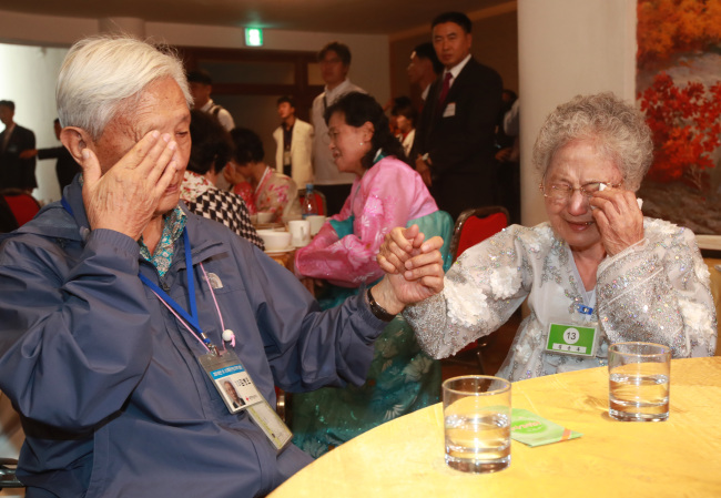 South Korean Kim Byung-oh and his North Korean sister Kim Soon-ok wipe their tears at their final meeting during the reunion event at the Kumgangsan Resort in North Korea on Wednesday. (Joint Press Corps)