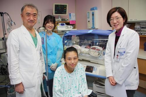 This photo provided by Seoul National University Hospital on Jan. 11, shows a mother who gave birth to triplets through two sets of births over a two-month period. (Yonhap)