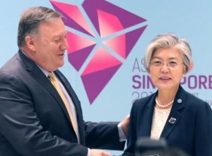 South Korean Foreign Minister Kang Kyung-wha (R) shakes hands with US Secretary of State Mike Pompeo ahead of their bilateral talks in Singapore on Aug. 4, 2018. (Yonhap)