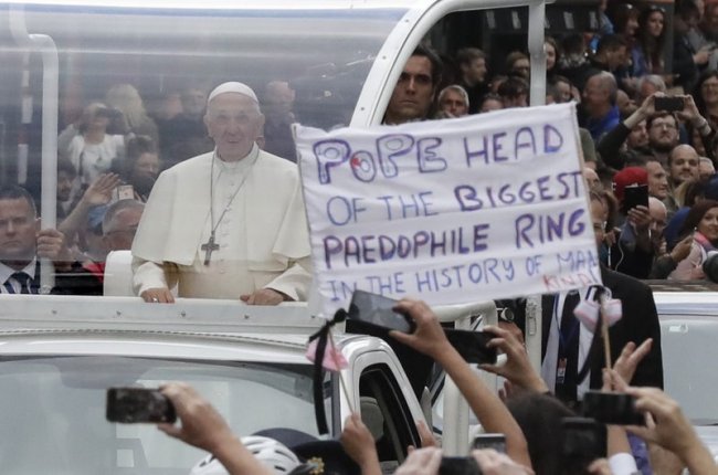 Pope Francis passes by a banner of a protester as he leaves after visiting St Mary’s Pro-Cathedral, in Dublin, Ireland, Saturday, Aug. 25. (AP)