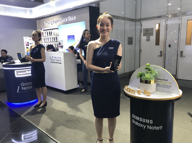 A model holds up a newly launched Galaxy 9 smartphone in a shopping mall at Ho Chi Minh, Vietnam (Lim Jeong-yeo/The Korea Herald)