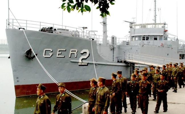 File photo showing North Korean soldiers looking at the US spy ship Pueblo, which was seized on Jan. 23, 1968, and is displayed at the Daedong river in Pyongyang. (Yonhap)