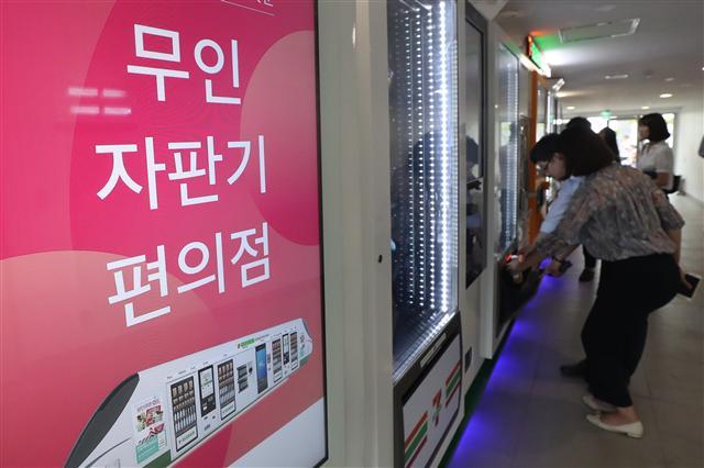 최저임금 인상을 둘러싼 갈등의 폭이 커지면서 유통업계의 무인자판기 바람도 거세다. 최저임금 인상에 따른 대비책이기도 하다. 세븐일레븐 본사에 시범운영 설치된 자판기형 편의점 ‘세븐일레븐 익스프레스’에서 직원들이 상품을 구매하고 있다.
[연합뉴스]