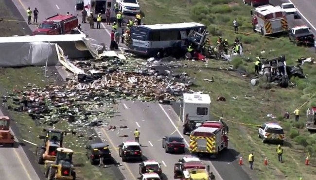 This photo from video provided by KQRENews13 shows first responders working the scene of a deadly collision between a Greyhound passenger bus and a semi-truck on Interstate 40 near the town of Thoreau, N.M., near the Arizona border, Thursday, Aug. 30. (AP)