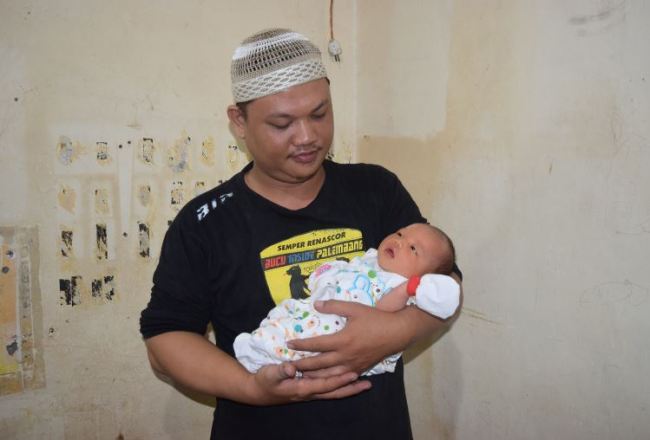 Yordania Denny holds his daughter Adibah Asian Games at their home in Palembang, Indonesia. (The Yomiuri Shimbun)