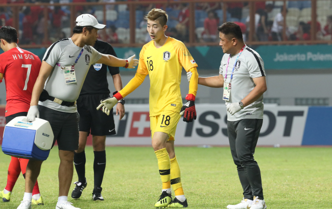 Jo Hyeon-woo (center) is replaced during a round of 16 match against Iran with a knee injury at the 18th Asian Games at Wibawa Mukti Stadium in Cikarang, Indonesia, Aug. 23. (Yonhap)