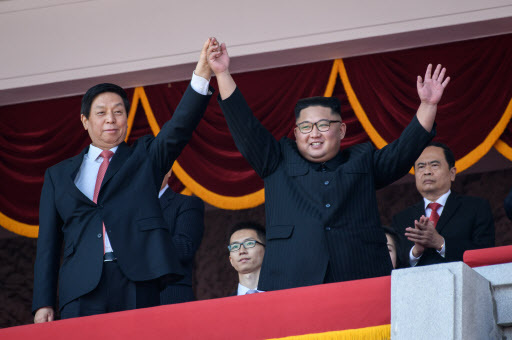 North Korea's leader Kim Jong Un (R) waves with China's Chairman of the Standing Committee of the National People's Congress Li Zhanshu (L) from a balcony of the Grand People's House on Kim Il Sung square following military parade and mass rally on September 9, 2018. (AFP)