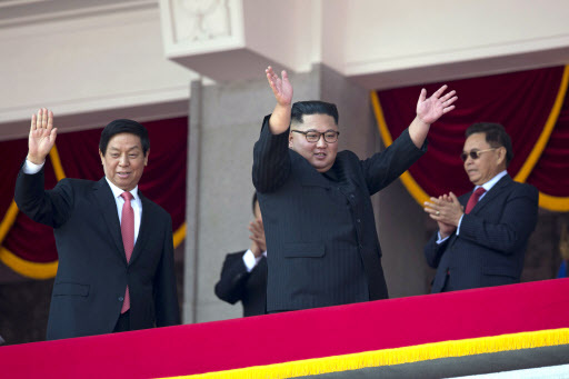 North Korean leader Kim Jong Un, right, raises his hands as he waves with China's third highest ranking official, Li Zhanshu, at left during a parade for the 70th anniversary of North Korea's founding day in Pyongyang, North Korea, Sunday, Sept. 9, 2018. (AP)
