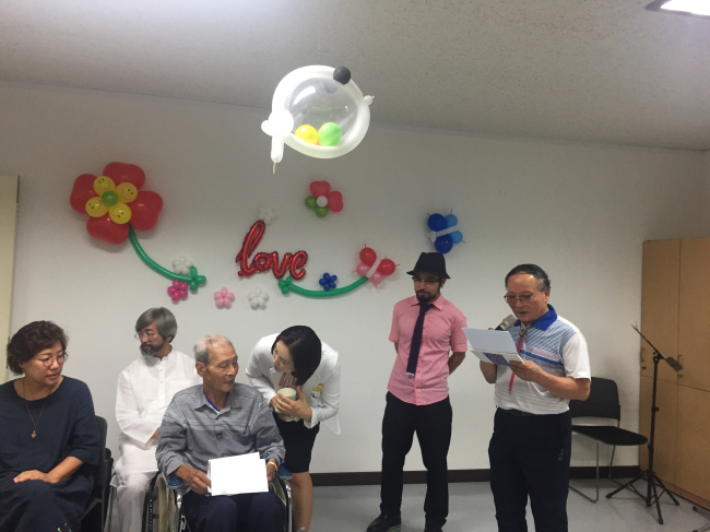 Kim Byung-guk (in wheelchair) listens to his colleague Kim Sun-tae (far right)'s speech during his own funeral at Seoul Metropolitan Dongbu Hospital on Aug. 14. (Claire Lee/ The Korea Herald)