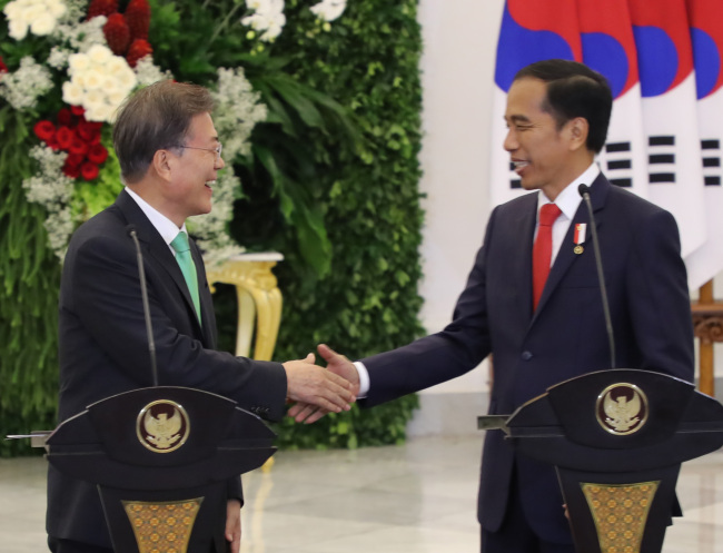 In a file photo taken on Nov. 9, 2017, South Korea’s President Moon Jae-in (left) and Indonesian President Joko “Jokowi” Widodo partake in a summit in Jakarta (Yonhap)