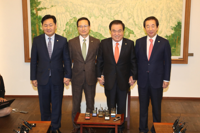 National Assembly’s Speaker Rep. Moon Hee-sang(third from left) locks hands with political parties’ floor leaders. (Yonhap)