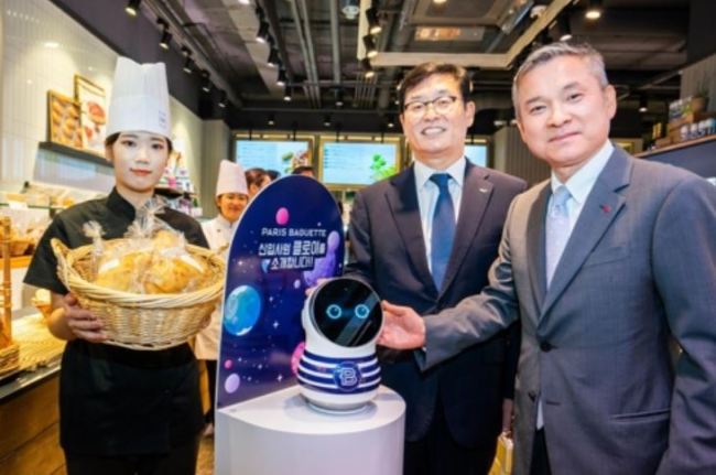 In this photo, provided by Paris Croissant Co., its CEO Kwon In-tae (C) poses for a photo with LG Uplus Corp. CEO Ha Hyun-hwoi (R) at a Paris Baguette store in Seoul on Sept. 11. (Yonhap)