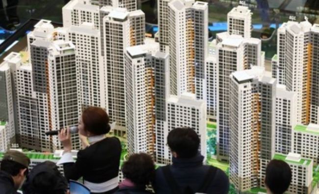In this photo taken March 16, 2018, visitors look at a model of DH Xi Gaepo apartment buildings in southern Seoul. (Yonhap)