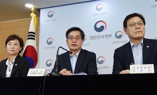 김동연 부총리 겸 기획재정부 장관이 13일 오후 서울 광화문 정부서울청사에서 ‘주택시장 안정대책’에 대한 관계부처 합동브리핑에서 종합부동산세 인상과 대출 규제를 핵심으로 하는 발표문을 낭독하고 있다. 왼쪽은 김현미 국토교통부 장관, 오른쪽은 최종구 금융위원장.  [제공=기획재정부]