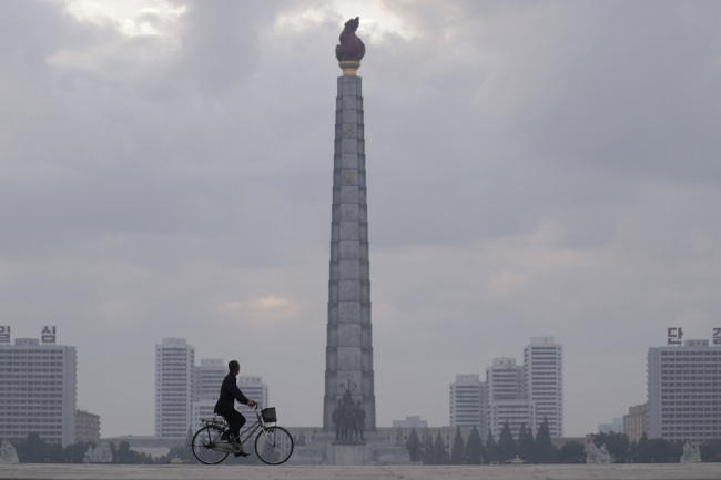 A North Korean rides a bike by the Tower of Juche Idea in Pyongyang, North Korea, Saturday. (Yonhap)