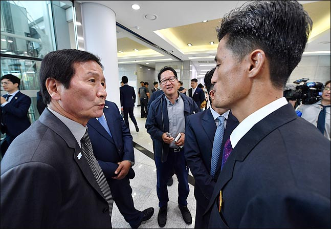 Chung Ki-sub (left), honorary chairman of the Corporate Association of the Kaesong Industrial Complex, talks with a North Korean official at the opening ceremony for the joint liaison office in the North’s Kaesong, North Hwanghae Province, Friday. (Joint Press Corps)