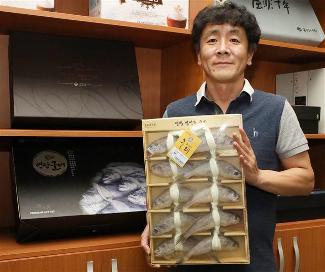 지난 13일 방문한 전남 영광군 법성포에 위치한 굴비 가공업체 ‘법성포 참맛’ 작업장 모습. 직원들이 굴비를 10마리씩 끈으로 엮는 ‘엮걸이’ 작업에 한창이다(왼쪽 사진). 조희돈 ‘법성포 참맛’ 대표가 굴비 선물세트를 들고 포즈를 취하고 있다.  [제공=롯데백화점]