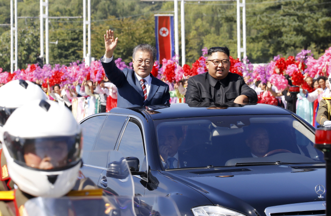South Korean President Moon Jae-in (left) and North Korean leader Kim Jong-un participate in an open-car parade in Pyongyang. (Joint Press Corps)