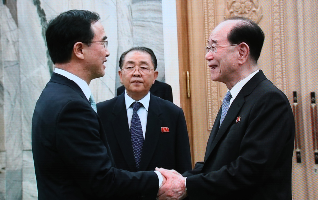 South Korea's Unification Minister Cho Myong-gyon shakes hands with North Korea's nominal head of state Kim Yong-nam. Yonhap