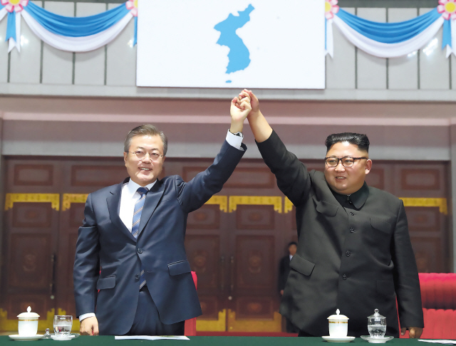문재인 대통령과 북한 김정은 국무위원장이 19일 밤 평양 5.1경기장에서 열린 남북정상회담 경축 대집단체조와 예술공연 ‘빛나는 조국’에 입장한 뒤 손을 들어 인사하고 있다. [평양사진공동취재단]