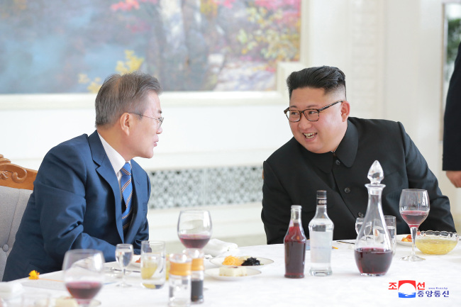 South Korean President Moon Jae-in (left) talks to North Korean leader Kim Jong-un (right) during a luncheon held in Pyongyang on Wednesday. (KCNA)