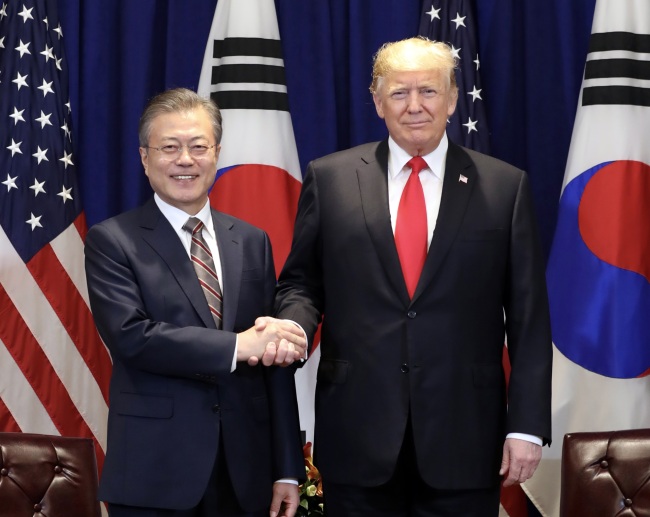 South Korean President Moon Jae-in (left) and US President Donald Trump shake hands in New York on Monday. (Yonhap)