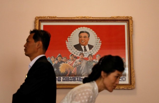 Pyongyang residents walk past an image of late North Korean leader Kim Il Sung at a teachers' training college in Pyongyang, North Korea, on Sept. 7. (Yonhap)