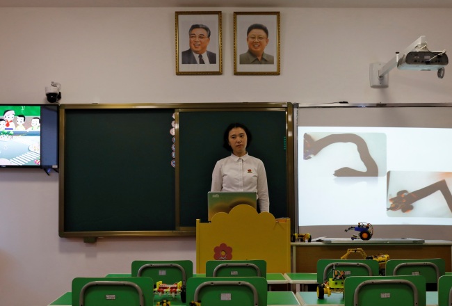 A student stands under the portraits of late North Korean leaders Kim Il Sung and Kim Jong Il during a lecture at a teachers' training college in Pyongyang. (Yonhap)
