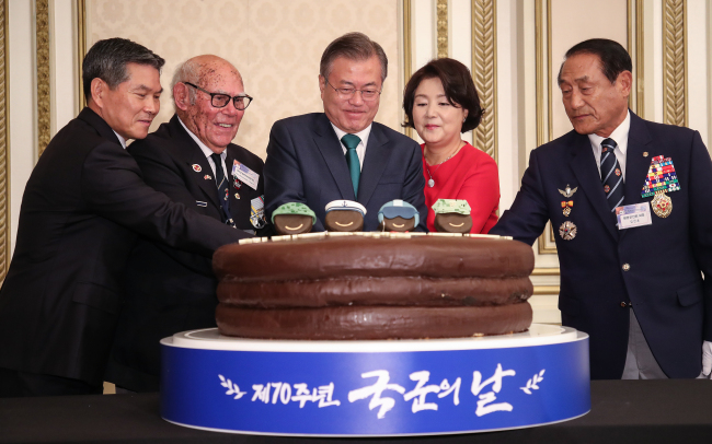 President Moon Jae-in and first lady Kim Jung-sook cut a cake shaped like a choco pie at an event held to commemorate the 70th Armed Forces Day at Cheong Wa Dae on Monday. (Yonhap)
