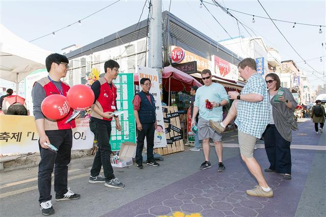 지난해 10월 롯데마트가 후원한 오산 오색시장 가을축제에서 상인들과 오색시장을 찾은 시민, 외국인 관광객들이 함께 즐거운 시간을 보내고 있다.  [제공=롯데마트]