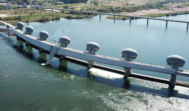 Water flows through a weir across the Namhan River in Yeoju, Gyeonggi Province, Thursday, after the weir was opened earlier that day. (Yonhap)