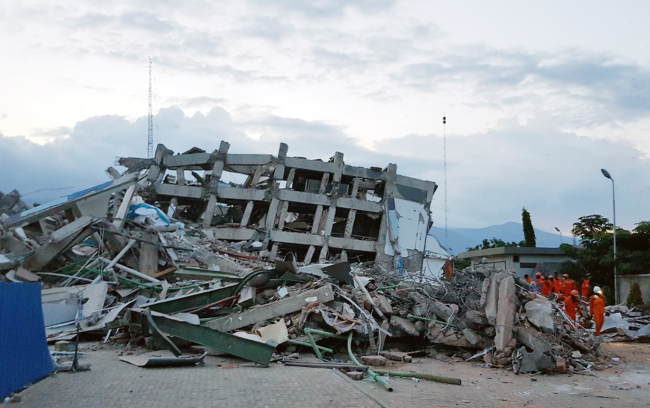 Emergency personnel approach a collapsed hotel in Palu, Indonesia. Yonhap