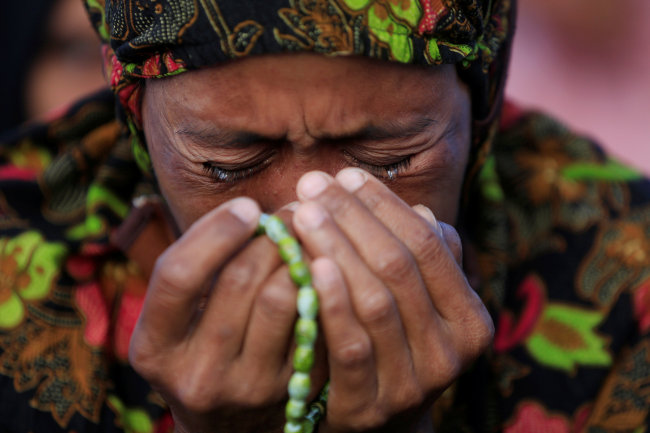 A woman cries as she attends a mass prayer for Palu at Talise beach for the one-week tsunami anniversary in Palu, Indonesia, October 5, 2018. (Reuters-Yonhap)