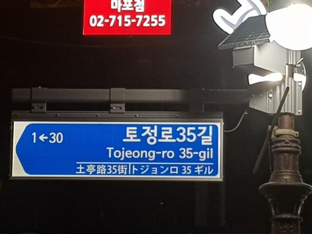 용강동 음식문화거리에 설치된 태양광 LED도로명판이 밤에도 토정로35길이라는 글씨가 환하게 잘보인다.