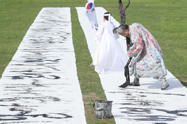 A 120-meter-long calligraphy writing of the preface for “Hunminjeongeum,” a book King Sejong published in 1446 on the Hangeul writing system, is on display at Gwanghwamun Plaza in Seoul on Tuesday. (Yonhap)