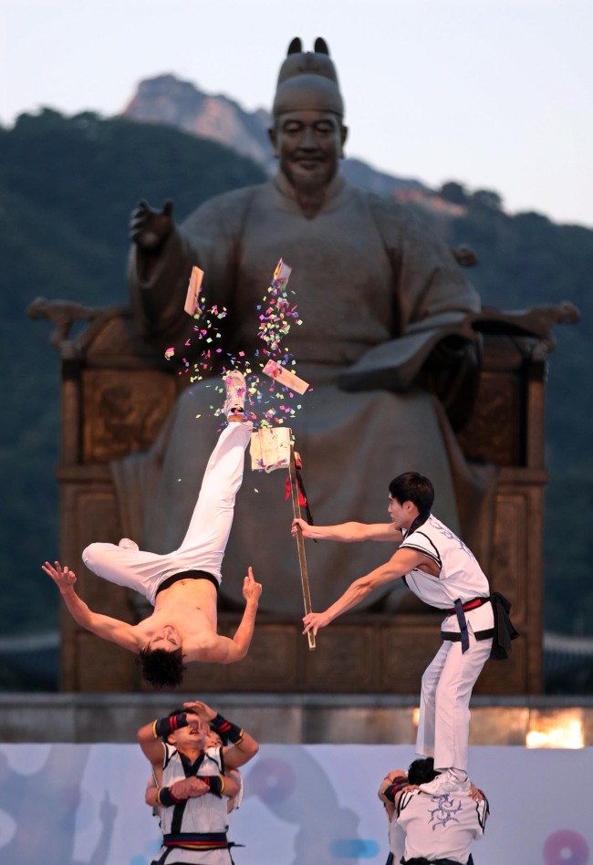 Artists performaing martial arts on stage during the official ceremony of Hangeul Day in front of Sejong statue in Gwanghwamun. (Yonhap)