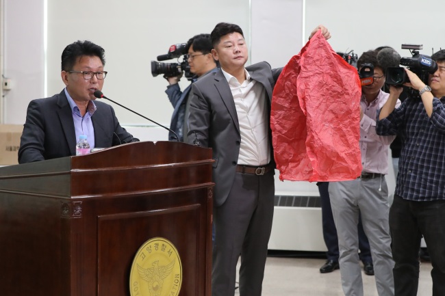 Jang Jong-ick (far left), an officer from the Geyonggi Bukbu Provincial Police agency, speaks during a press conference Tuesday. Another officer is holding a sky lantern that police believes has caused massive fire at an oil storage facility in Goyang, Gyeonggi Province, Sunday. (Yonhap)