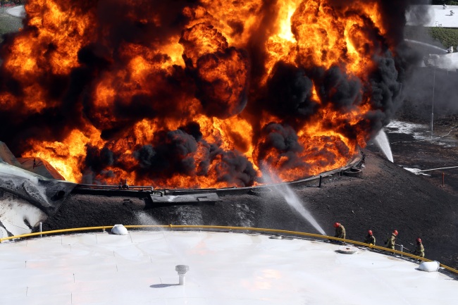 Fire fighters try to extinguish massive fire that erupted at a large oil storage facility in Goyang, Gyeonggi Province, Sunday (Yonhap)