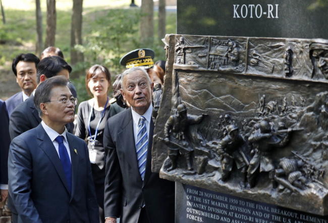 In a file photo taken on June 28, 2017, resident Moon Jae-in looks at the "Chosin Few Battle Monument," with former Marine Corps Lt. Gen. Stephen Olmstead, at the National Museum of the Marine Corps in Triangle, Virginia. (AP-Yonhap)