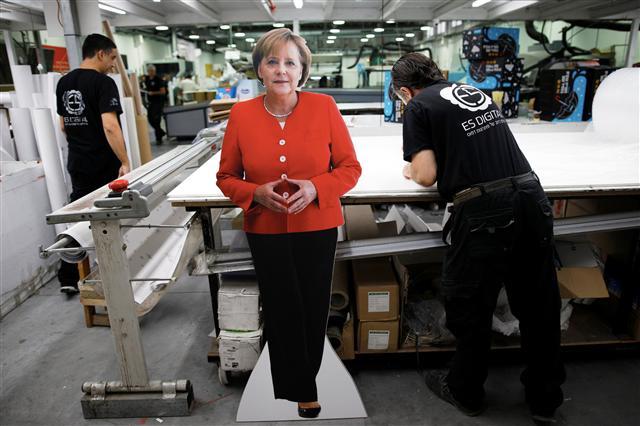 <YONHAP PHOTO-0469> Employees work near a cardboard cutout of German Chancellor Angela Merkel, which will be used in a protest held by working women in Israeli high-tech companies, at a printing shop in Yavne, Israel October 9, 2018. Picture taken October 9, 2018. REUTERS/Amir Cohen/2018-10-11 04:25:35/ <저작권자 ⓒ 1980-2018 ㈜연합뉴스. 무단 전재 재배포 금지.>
