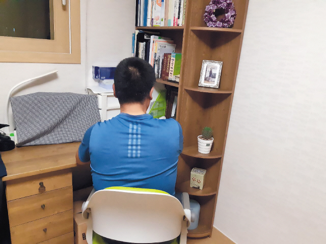 지난해 3월 딸을 잃은 서수진(53) 씨가 딸의 책상에 앉아 있는 모습. 그는 아이가 생전 쓰던 책들을 모두 그대로 간직하고 있었다.   [서수진 씨 제공]