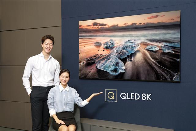 삼성디지털프라자 학여울점에서 모델들이 퀀텀닷 기술에 8K 해상도를 적용해 압도적인 화질을 구현하는 ‘QLED 8K’(82인치 Q900R 제품)를 소개하고 있다.  [제공=삼성전자]