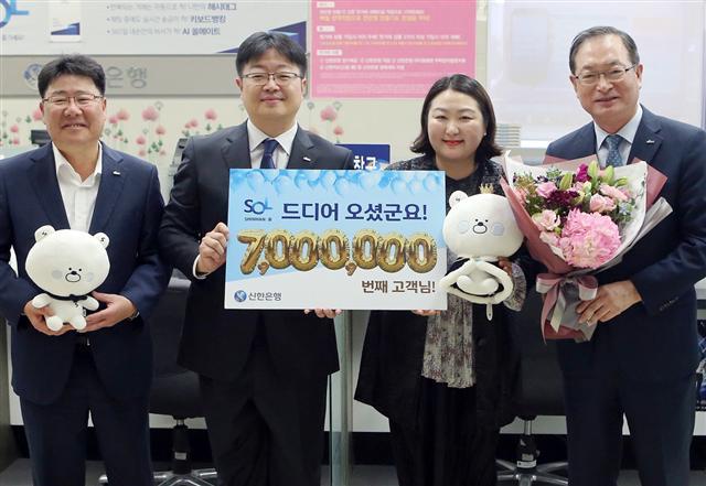 지난 17일 서울 강남구에 있는 신한은행 영동지점에서 ‘쏠(SOL)’의 7백만번째 가입 고객인 이운정씨(오른쪽 두번째)에게 순금 7돈을 기념품으로 전달했다. [제공=신한은행]