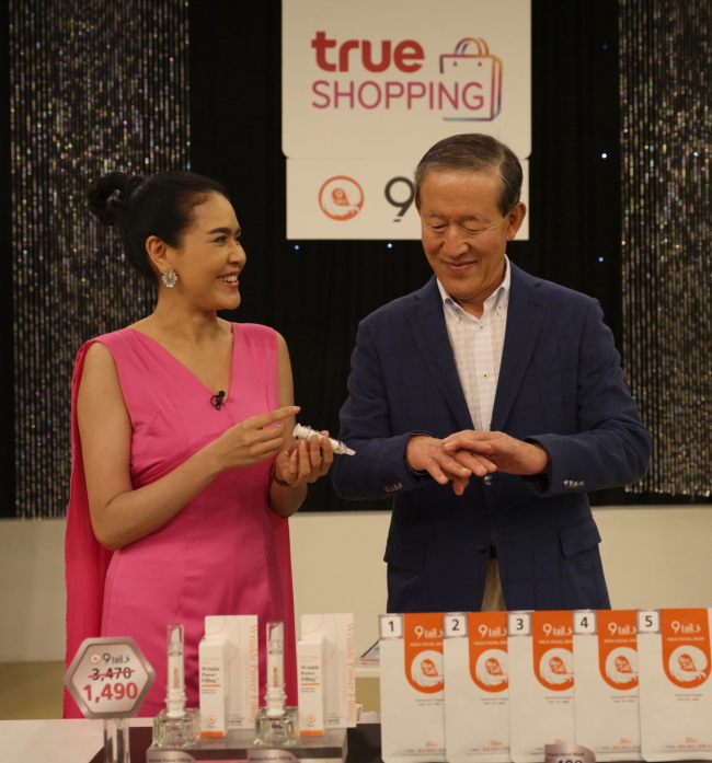 GS Group Chairman Huh Chang-soo (right) tries a product exported by South Korean company 9tails at a studio for True GS, jointly set up by GS Homeshopping, TrueVisions, CP All and Mall Group of Thailand. (GS)