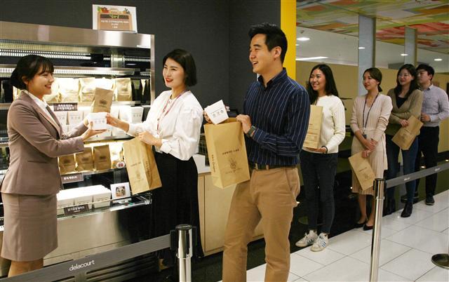 수원 ‘삼성 디지털시티’ 사내 식당에서 임직원들이 테이크아웃 음식이 담긴 재생 종이봉투를 들고 있다.  [제공=삼성전자]
