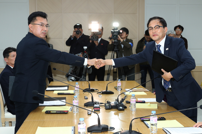 Kim Song-jun, a senior official with the North Korea’s Ministry of Environmental Protection, left, shakes hands with Park Chong-ho, deputy chief of the Korea Forest Service at a meeting held in the South-North joint liaison office in Kaesong, North Korea on Monday. (Yonhap)